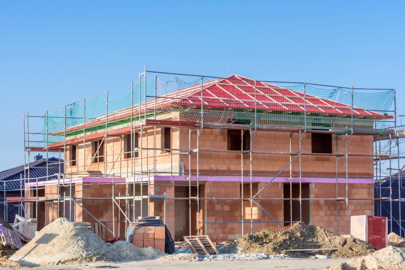 Neubau eines Hauses mit Baugerüst und unvollständigem Dach in ländlicher Umgebung.