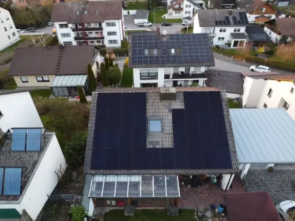 Dachansicht von Wohnhäusern mit Solaranlagen und einem kleinen Pool.