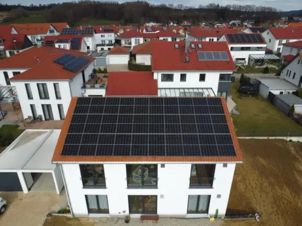 Moderne Häuser mit Solarpanelen auf den Dächern in einem Wohngebiet.