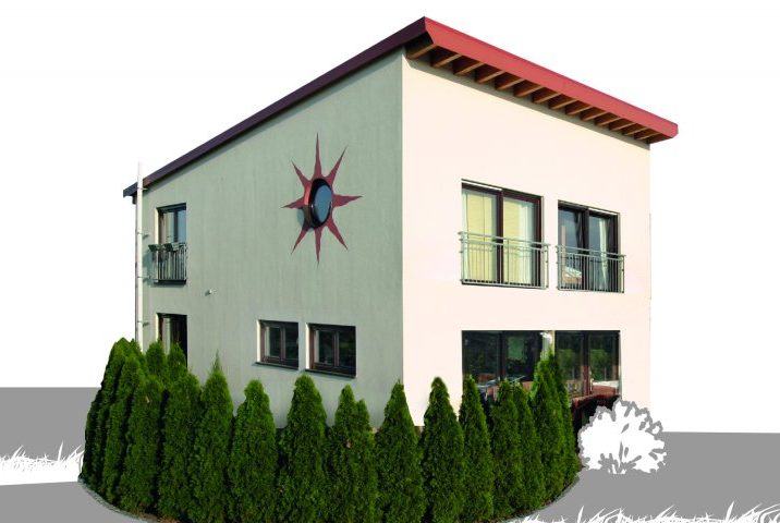 Modernes Gebäude mit grünem und weißem Anstrich, Sonnenmotiv und Heckenfront.